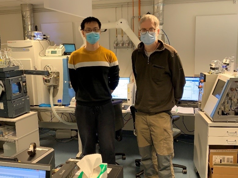 A picture of Zhongfei Ren and Ulrich Bergmann standing in a laboratory